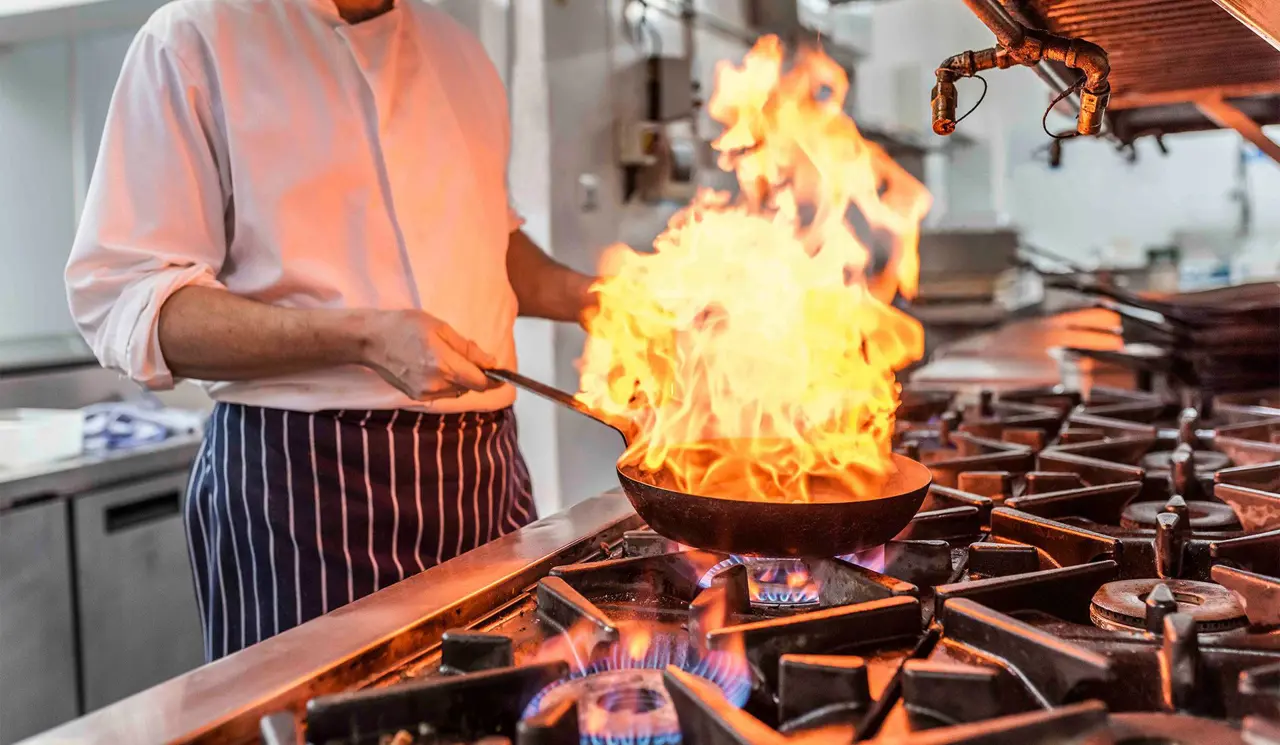 Chef cooking in Seafood and Grill Restaurant kitchen at The Brudenell Hotel, Aldeburgh