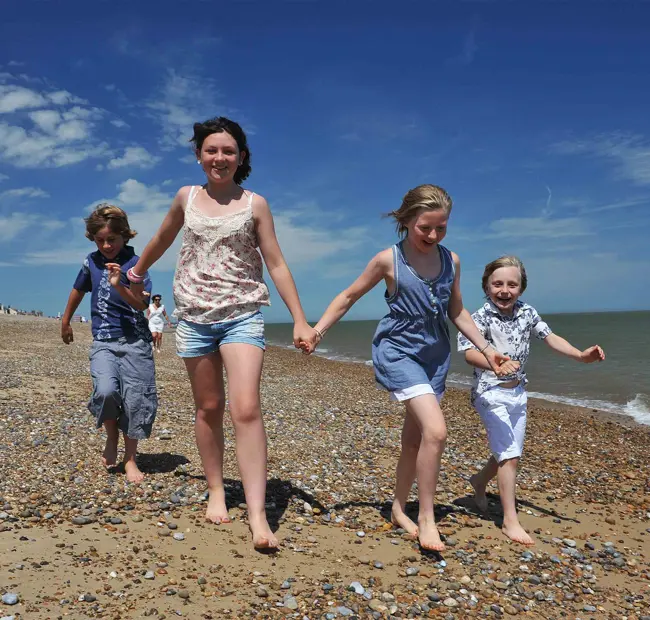 Aldeburgh Beach, family running on pebbly beach, close up