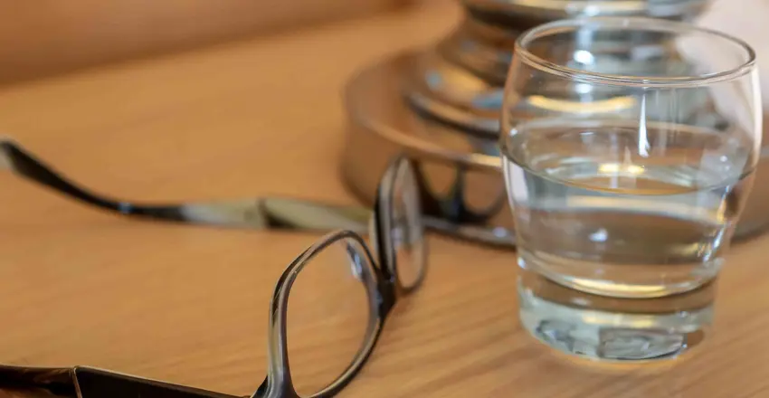 Glasses and glass of water on bedside table at The Brudenell Hotel, Aldeburgh